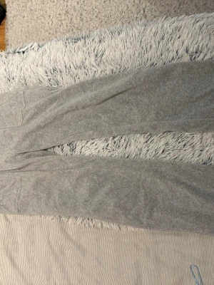Grå mjukisbyxor Juicy Couture storlek M - Säljer ett par grå mjukisbyxor från Juicy Couture i storlek M. Jättefint skick, ända slitaget är att dom silvriga detaljerna på snörerna är borta. 