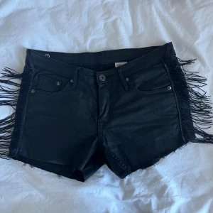 Svarta fransshorts från H&M - Custom made! Sytt ditt fransarna själv på dessa snygga svarta shorts från H&M! De har låg midja och fransar längs sidorna för en edgy vibe. Perfekta för dig som vill sticka ut 🖤