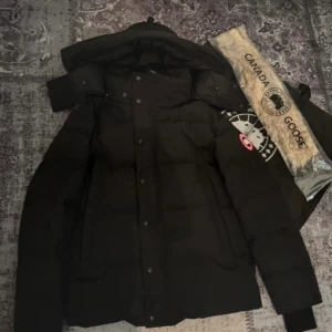 Svart dunjacka från Canada Goose STORLEK S - Säljer en svart dunjacka från Canada Goose i storlek S. Jackan har klassisk pufferstil, avtagbar huva och tydlig logga på ärmen. Materialet är slitstarkt och fyllningen är dun, perfekt för kalla vinterdagar. Medföljer originalpåse och pälskrage.