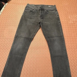 Grå jeans från Dondup, storlek 32 - Snygga grå jeans från Dondup i klassisk femficksmodell. Jeansen har raka ben och normal passform, med subtila slitningar och en cool tvättad look. Materialet är mjukt jeans och midjan är midwaist. Perfekt för dig som gillar stilrena och tidlösa jeans.