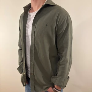 Mörkgrön Morris skjorta - Nu säljer vi ännu en snygg Morris skjorta som passar till alla tillställningar! Skjortan är i väldigt bra skick! Du ska kunna uttrycka stil utan att det kostar för mycket!🕺🍾💼🤩  Storlek👔: M Nypris💰:  ca 1300 kr