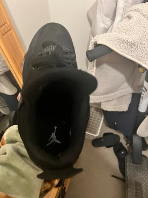 Svarta Nike Jordan 4 sneakers blackcat  - Priset kan diskuteras vid snabbt köp .Säljer ett par svarta Nike Jordan 4 sneakers med cool meshpanel på sidorna och klassisk Jumpman-logga på plösen. Skorna har snörning, platt sula och detaljer i syntet och mocka. Perfekt för dig som gillar streetwear och vill ha en clean look. 