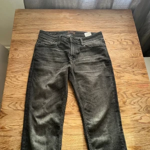 Svarta jeansbyxor med straight fit - Snygga svarta jeans från Levi's med klassisk femficksdesign och raka ben. Jeansen har en lätt tvättad look med subtila slitningar och är tillverkade i mjukt bomullsjeansmaterial. Passar dig som gillar en enkel och stilren vibe.