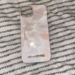 Ideal of Sweden iPhone 14 Plus Case Pearl Marble - Elegant mobilskal till iPhone 14 Plus från Ideal of Sweden med Pearl Marble-design. Skalet är i nyskick och är ej använt och ligger kvar i förpackningen.