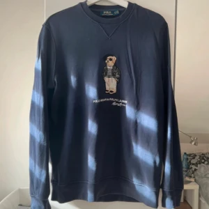 Ralph lauren - Polo bear sweatshirt - Mörkblå sweatshirt från Polo Ralph Lauren med ikoniska Polo Bear broderad på bröstet. Tröjan har rund hals, ribbade muddar och är i mjuk bomull. Perfekt för dig som gillar klassisk och stilren streetwear med en twist. Skicket är mycket bra och pris absolut diskuterbart. Kontakta mig om minsta lilla!😊