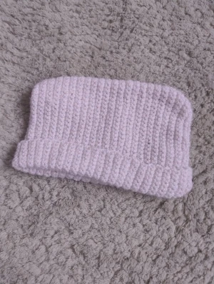 Handgjord vit virkad mössa - Supermysig virkad mössa gjord i glittrigt garn. Perfekt för kalla dagar och ger en chill vibe till din outfit. Mjuk och skön, passar de flesta huvuden. Enkel att matcha med jacka eller hoodie.