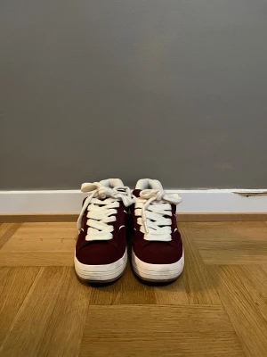 Vinröda sneakers från Bershka - Snygga vinröda sneakers från Bershka med vit tjock sula och breda vita snören. Skorna  är tillverkade i mocka-liknande material med mjuk vadderad insida. Perfekt för dig som vill ha ett par varma skor nu till vintern. 