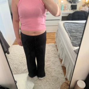 Rosa ribbad linne - Säljer en ljusrosa ribbad linn, Toppen är croppad och ärmlös med rundad hals och breda axelband. Perfekt för dig som gillar en enkel men snygg look. 