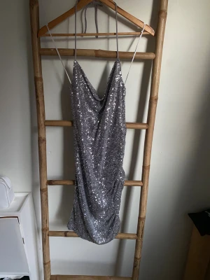 Glittrig silverklänning från Bik Bok XS - Supersnygg kort silverklänning från Bik Bok med draperad framsida. Klänningen är täckt av glittriga paljetter och har en figurnära passform som verkligen sticker ut. Perfekt för dig som vill glänsa extra mycket!