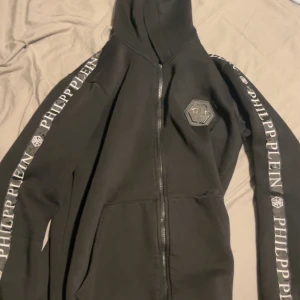  Philipp Plein hoodie - En svart hoodie från philipp plein, det är ett hål i fickan men det går att sy hur enkelt som helst har bara inte pallat. 