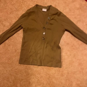 Ribbad beige kofta från Vila - Säljer en beige ribbad kofta från Vila i storlek L. Koftan har v-ringning, lång ärm och fyra snygga knappar framtill. Materialet är mjukt och stretchigt, perfekt för lager-på-lager. Enkel och clean design som funkar till många olika stilar.