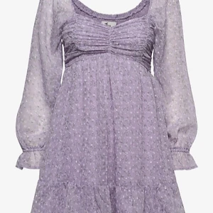 Ljuslila blommig klänning Hollister XS - Supersöt ljuslila kortklänning från Hollister med små vita blommor och gröna blad. Klänningen har långärmade, transparenta ärmar med volang vid ärmslut och en rynkad byst. Fluffig kjol med volangkant och flowy passform. Perfekt för vår och sommar! 