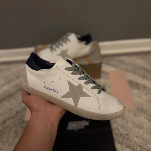 Golden goose skor  - Helt nya och oanvända par skor. Storlek 42 som passar som vanligt. Allt på bild ingår med skorna. Fraktar inom 24h. Marinblå häl