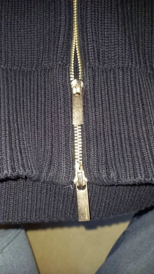 kofta från Selected Homme - Snygg mörkblå stickad kofta från Selected Homme med ribbad struktur och hög krage. Koftan har en silverfärgad tvåvägsdragkedja framtill och långa ärmar. Perfekt för att hålla värmen under kyliga dagar och passar till många olika stilar. Köpte för 750 men aldrig använt pris kan diskuteras vid snabb affär 🤝🤝🤗