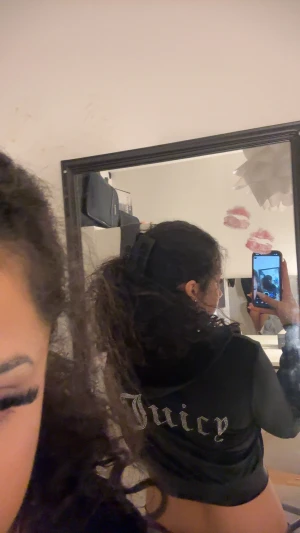 Juicy Couture svart velourjacka - Svart croppad velourjacka från Juicy Couture med huva och glittrig Juicy-text på ryggen. Jackan har dragkedja framtill och långa ärmar. Perfekt för dig som vill ha en ikonisk och trendig look samt en touch av y2k stilen! 