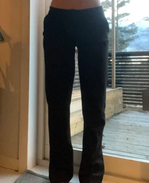 Svarta kostymbyxor med rak passform - Snygga svarta kostymbyxor med rak passform och klassisk midja. Byxorna har bälteshällor, knapp och dragkedja framtill samt sidfickor och inga fickor på baksidan. Perfekta för en clean och stilren look. 