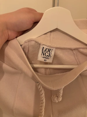 Mjukisset från Lounge - Ett ljust beige mjukisset från LOUNGE i storlek xs!😇  Både tröjan och byxorna är fodrade så de passar jätte bra nu till vintern! Tröjan är cropad och slutar mellan bysten och naveln.  Setet är aldrig använt! Hittade inte detta på hemsidan så tror det har utgått från deras sortiment!