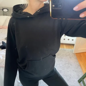 Svart hoodie med huva och ficka - En svart hoodie med stor huva och magficka. I storlek xs men passar mig perfekt som har s-m i vanliga fall. 