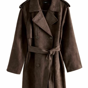 Brun trenchcoat i mocka från Next - Brun  trenchcoat i mocka-look från Next men köpt från Zalando storlek XS men passar även S, köpt för 1700krJackan har en klassisk krage, dubbelknäppning, axelklaffar och bälte i midjan. Perfekt för dig som vill ha en stilren och tidlös vibe. Långa ärmar och slits bak för extra rörelsefrihet.