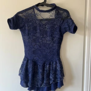 Marinblå/lila glittrig konståkningsklänning - Inga defekter, medföljande hårband. Passar ca strlk S