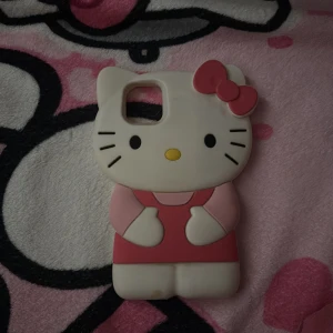 Hello Kitty mobilskal - Sött Hello Kitty mobilskal för iPhone 11.  i mjukt silikonmaterial. Passar telefon med fyrkantigt kamerahål. Skalet är i gott skick med mindre tecken på användning, perfekt för dig som vill ge din mobil en unik och lekfull look.