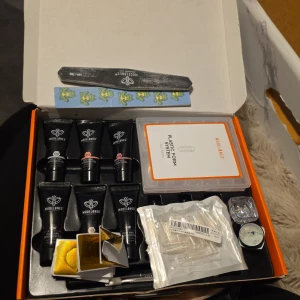 Modelones nagelförlängningskit - Komplett nagelförlängningskit från Modelones med flera tuber builder gel i olika nyanser, plastformar, nagelfilar, glitter och tillbehör. Perfekt för att skapa snygga och kreativa naglar hemma. Innehåller även dekorationer och verktyg för nageldesign. Två av gelén är använd