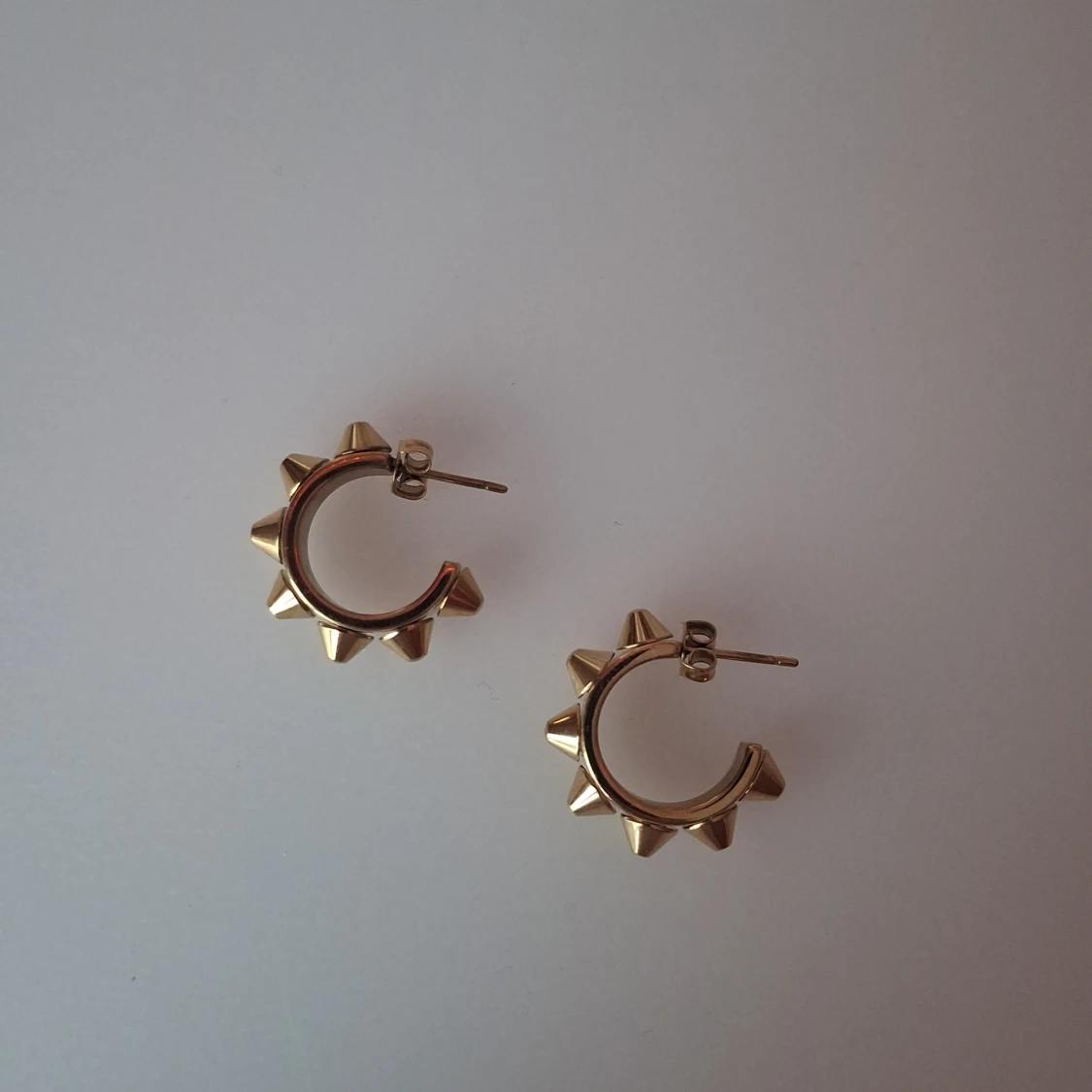 Guldiga örhängen med nitar från Edblad 