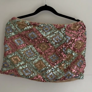 Paljettkjol i pastell och guld - Superfin kortkjol täckt av paljetter i pastellrosa, mintgrönt, ljusblått och guld. Kjolen har ett rutigt mönster av paljetter som ger en riktigt glittrig och färgglad look. Perfekt för dig som vill sticka ut och älskar färg och glitter. Storlek S/M💕