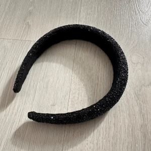 Svart glittrigt diadem - Snyggt svart diadem med glittriga stenar över hela ytan. Helt oanvänt och i topp skick 