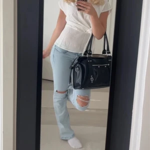 Ljusblå ripped jeans low waist - Säljer ett par ljusblå jeans med slitna detaljer vid knäna. Jeansen har klassisk femficksdesign och är tillverkade i denim. Perfekta för dig som gillar en avslappnad och trendig look. Low waist🩵