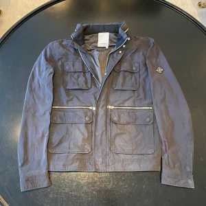 J.Lindeberg Field jacket  - Snygg Field jacket fårn j. Lindberg i bar sick 7/10. Jackan är i L. Det finns en utfäll bra luva, se bild 5. Skorv gärna vid funderingar ✅ Priset är ej hugget i sten 🤝