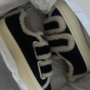 Svarta inuikii sneakers - Helt oanvända & slutsålda sneakers från Inukki med fluffiga teddy-detaljer och breda kardborreband. Skorna har en chunky vit sula. Säljes då de är för små 