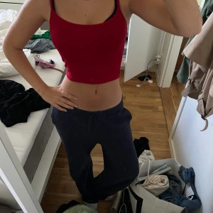 Röd croppad linnetopp - Snygg röd croppad linnetopp med smala axelband och rund halsringning. Perfekt för varma dagar eller att styla lager på lager. Enkel och stilren design som är lätt att matcha med olika outfits.