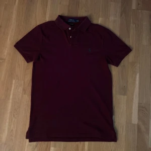 Polo Ralph Lauren Piké - Säljer en tvärfet vinröd Polo Ralph Lauren piké i väldigt bra skick, knappt använd 🙌🏼 Nypris ligger på 1500kr. Hör av er vid minsta lilla fundering🗣️  Axelbredd: 40cm Längd: 68cm