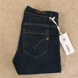 Helt Nya Dondup George med Tags - Säljer dessa mörklblåa dondup jeans i modellen George. De är helt nya och har tagsen kvar och allt kvar. Orderbekräftelse/Kvitto finns ifall någon av er tvivlar på äktheten. De är i storlek W30 och kostar ~3300kr retail men säljer nu dessa för endast 1399kr. Hör av er vid frågor eller bud.
