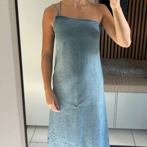 Klänning - Klänning i jeansmaterial som använts endast en gång. Banden kan bäras på olika sätt(se bilder). Jag är 161 cm och den sträcker sig ner till mina anklar ungefär.