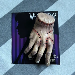 Wednesday Thing Hand Clip - Realistisk hand från Wednesday-serien, föreställande 'Thing'. Perfekt för cosplay eller till halloween. Handen har detaljerade fejksömmar och en klämma för enkel fastsättning på kläder. Produkten är använd en gång och levereras med originalförpackningen. Frakten kostar också! :)