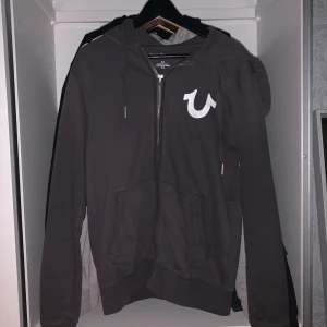 True Religion Hoodie - Är det någon som använder denna app fortfarande??? (Kom med svar i dm…) iallafall nu har vi en riktig feeet TR tröja till salu. Han sitter bra om man ligger på snittvikt/längd hos oss män. Kan ha tag’en kvar om jag minns rätt. Beställd från nätet och den är i prima skick. Ville knappt sälja den men kom på att man har ”bills to pay”. Så kom gärna med bud vid snabb affär och kom gärna inte med bud vid skitsnack.