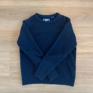 Mörkblå stickad tröja Jack & Jones - Mysig mörkblå stickad tröja från Jack & Jones med rund halsringning och ribbade muddar. Perfekt för kyliga dagar och enkel att matcha med jeans eller chinos.