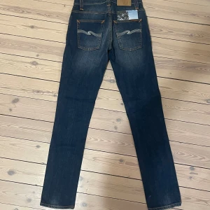 Nudie Grim Tim - Snygga mörkblå jeans från Nudie Jeans med klassisk femficksdesign och kontrastsömmar. Jeansen har raka ben. Materialet är mjukt och stretchigt denim som sitter skönt hela dagen.