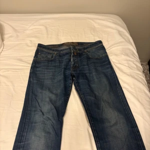 Jacob Cohen blå jeans straight fit - Snygga blå jeans från Jacob Cohen med klassisk straight fit och handgjorda detaljer. Jeansen har fem fickor, kontrastsömmar och en unik knapp med broderade färgprickar. Tillverkade av utvalda japanska tyger och italienskt hantverk. Perfekt för dig som gillar premium denim.