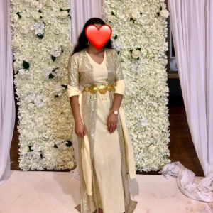 Kurdisk klänning  - Kurdiskt  långklänning i champagnefärg med glittrig paljettbeströdd överdel och lång ärm. 