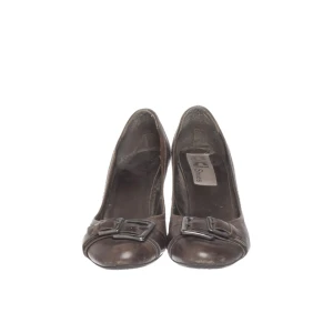 Bruna pumps/klackskor - Snygga bruna pumps från KIKI Shoes med rund tå och dekorativa spännen framtill. Skorna har en klassisk hög klack och har en stilren och unik design. Köpte dem begagnade men de var tyvärr för stora för mig så har inte kunnat använda dem! De har några defekter som små repor, kan ses på sista bilderna, annars är de som nya! Något stora i storleken, tror de passar 37,5-38 bättre. 