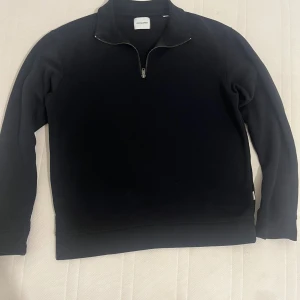 Svart half zip-tröja Jack & Jones - Priset kan diskuteras!!! Svart långärmad tröja från Jack & Jones med half zip-dragkedja och hög krage. Enkel och stilren design, perfekt för lager-på-lager. Mjuk och skön bomullskänsla, passar till jeans eller joggers.
