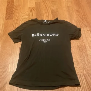 Svart Björn Borg t-shirt med tryck - Svart t-shirt från Björn Borg med vitt tryck på bröstet där det står 'BJÖRN BORG STOCKHOLM 1956'. Klassisk rund hals och korta ärmar. Skön och enkel modell som passar till det mesta.