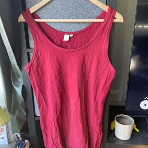 Röd linnetopp från Sunshine 365 - Snygg röd linnetopp från 365 i mjuk bomull. Modellen är ärmlös med breda axelband och rundad halsringning. Perfekt att styla med jeans eller shorts för en chill look. Färgen är djup röd och materialet känns skönt mot huden.