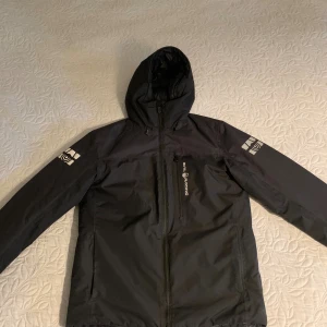 Svart vindjacka från Sail Racing - Säljer nu min vinterjacka som aldrig kom till användning då den inte passa mig. Den är i ny skick 10/10 som sagt aldrig använd. Köpte på stadium för cirka -: 3700 kr. Den är vatten tät och isolerar värme mycket bra. 