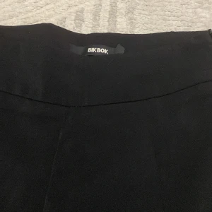 Svarta vida byxor från BikBok - Svarta byxor från BikBok i storlek 34. De har hög midja och ett snyggt, vida ben. Perfekta för en clean och stilren look. Materialet känns mjukt och följsamt, vilket gör dem riktigt bekväma att bära.