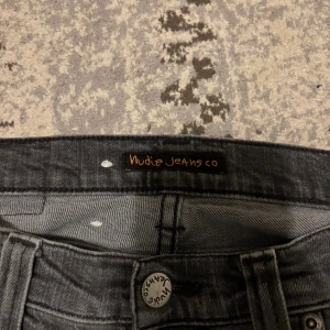 Svarta jeans från Nudie Jeans Co - Snygga svarta jeans från Nudie Jeans Co med klassisk femficksdesign och broderad bakficka. Jeansen har en smal passform och är tillverkade i mjukt denimtyg. Perfekta för dig som gillar en stilren look.