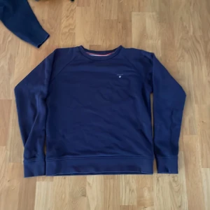 Mörkblå sweatshirt från GANT - Snygg mörkblå sweatshirt från GANT med broderad logga på bröstet. Tröjan har rund halsringning, ribbade muddar och är tillverkad i mjuk bomull. Perfekt för en clean och klassisk stil.